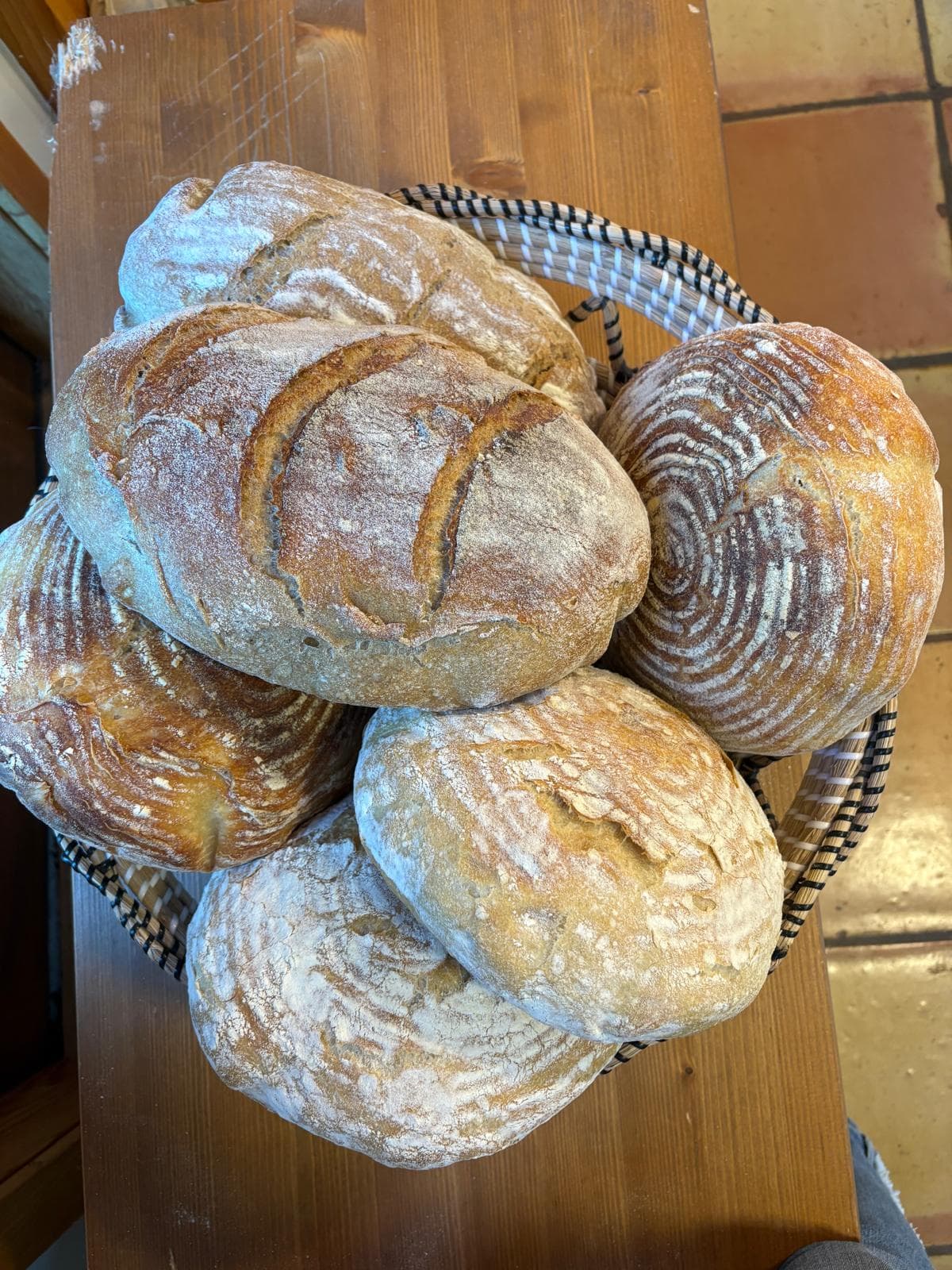 A basket piled high with fresh sourdough loaves