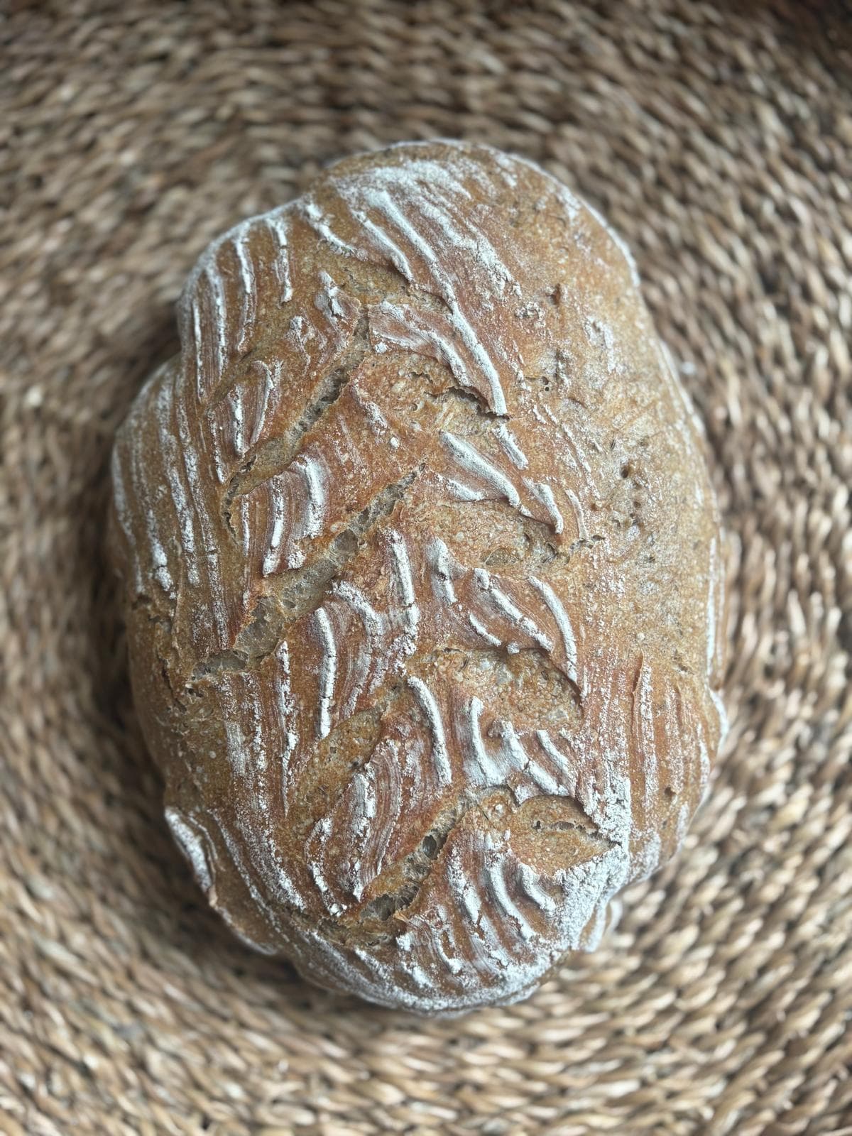 An oval rye loaf with herringbone scoring