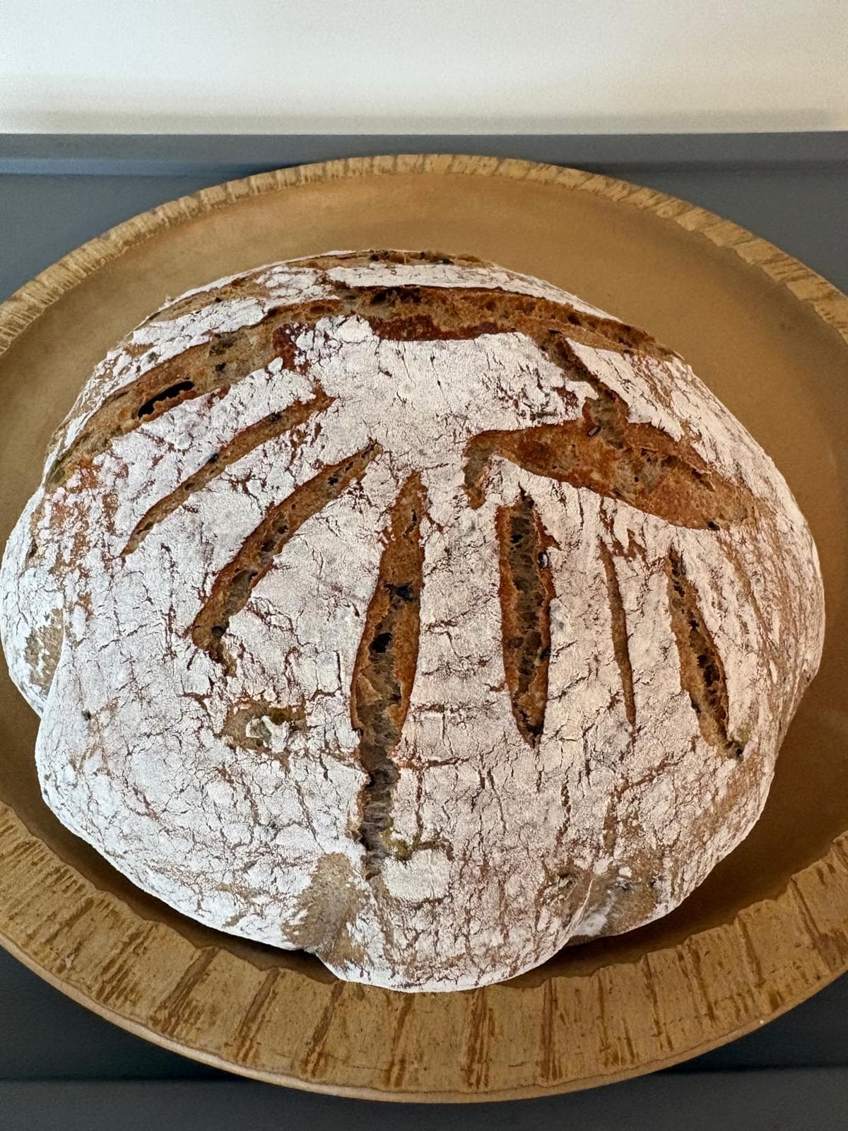 A seeded rye loaf with sunburst scoring