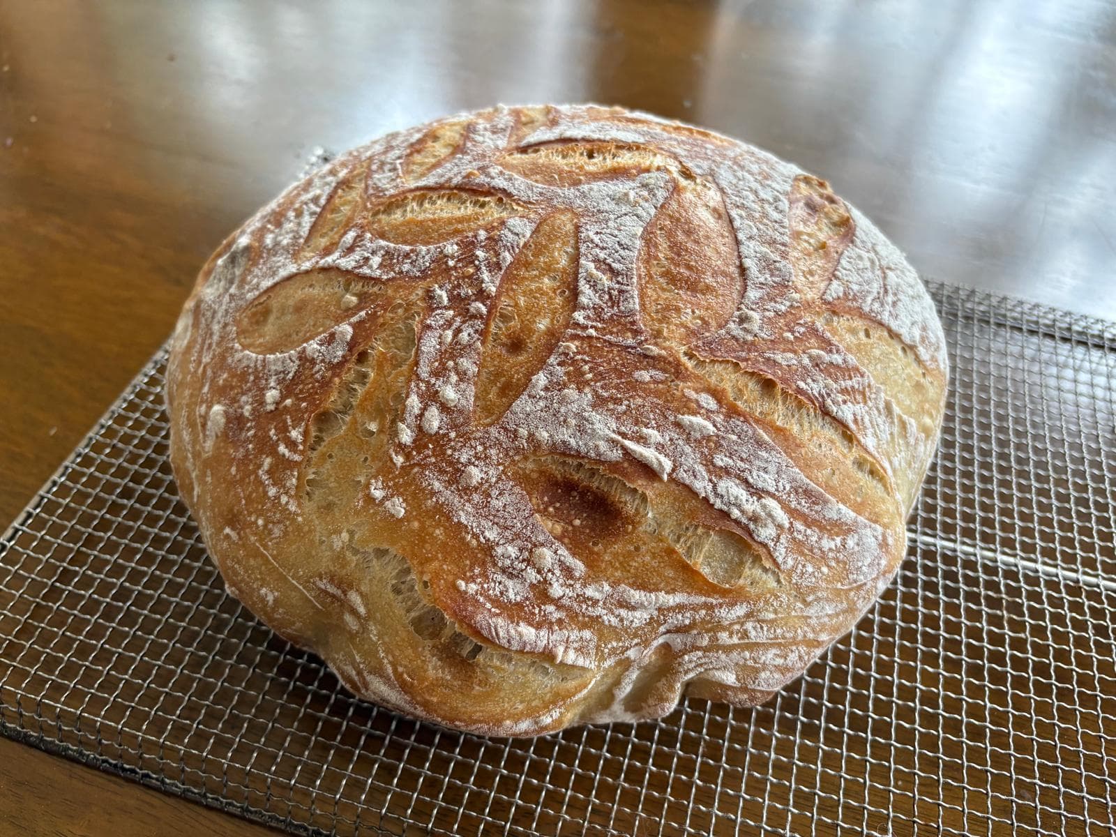 A golden round sourdough on a rack